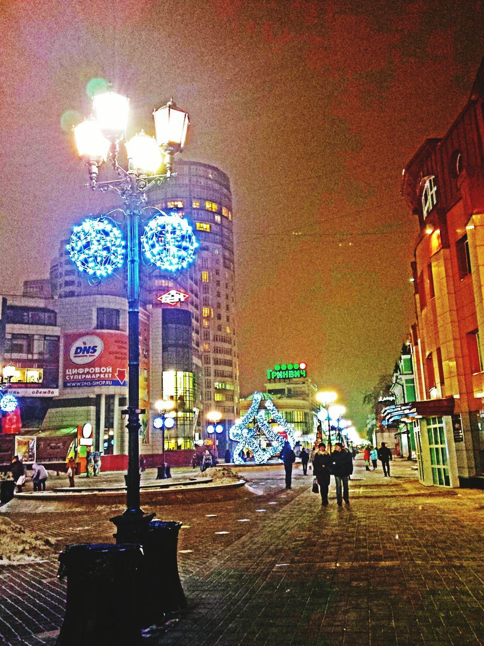 illuminated, architecture, built structure, building exterior, night, lighting equipment, men, street, city, street light, person, walking, city life, lifestyles, text, large group of people, leisure activity, incidental people, communication