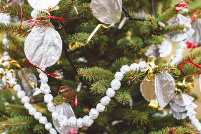 Aluminium foil handmade decoration on a christmas tree outdoor. diy creative ideas for children