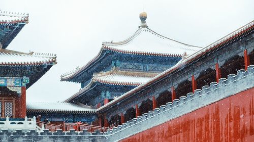 Low angle view of traditional building during snowfall