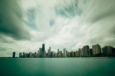 View of cityscape against cloudy sky