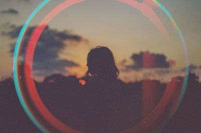 Silhouette woman seen from light trail during sunset