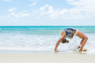 Full length of woman on beach against sky