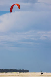 Person paragliding against sky