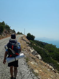 Rear view of man looking at mountain against sky