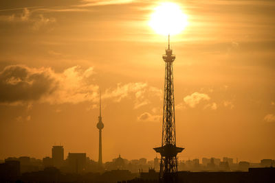 Silhouette fernsehturm and television tower against dramatic sky during sunset