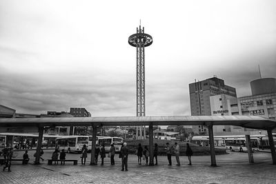 People waiting at bus stop in city