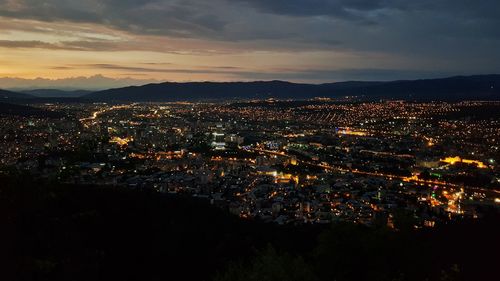 High angle view of illuminated city against sky at night