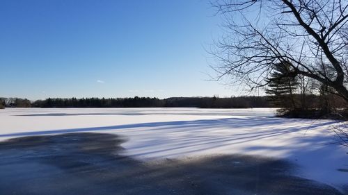 Scenic view of frozen landscape against clear blue sky