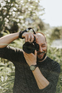 Portrait of smiling man holding camera