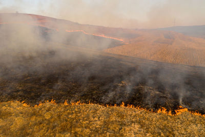 Aerial view of spring dry grass burning field. shrubs and common waste are burned in romania