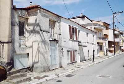 Residential buildings by street against sky in city