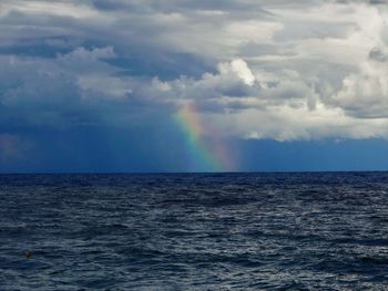 Scenic view of rainbow over sea against sky