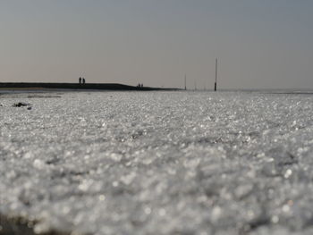 Surface level of beach against clear sky