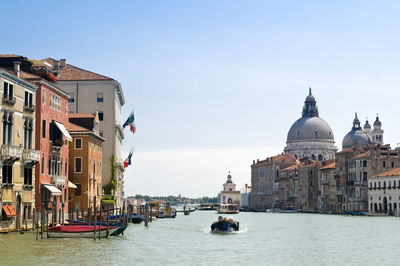 Boats in canal against clear sky