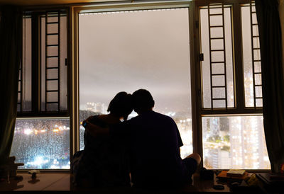 Rear view of silhouette man and woman in glass window