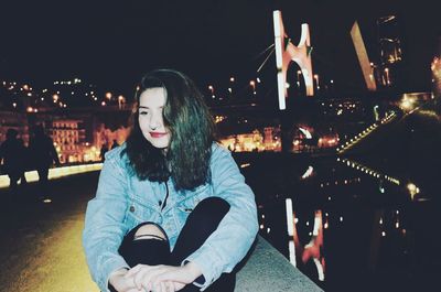 Young woman in city at night