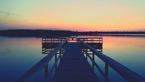 Pier over scenic lake at sunset