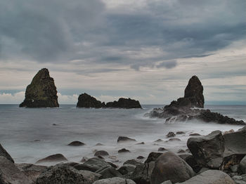 Rocks on beach against sky