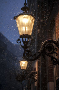 Low angle view of illuminated light bulb during winter