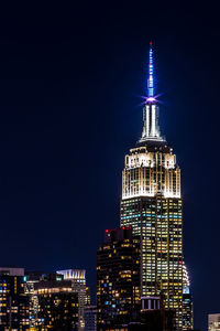 Low angle view of illuminated empire state building in city at night
