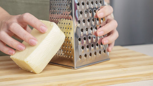 Cropped hands of man using mobile phone on table