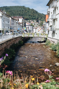 Bridge over river by buildings in town