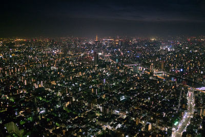 Illuminated cityscape against sky at night