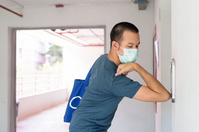 Portrait of young man standing at home