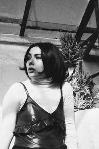 Young woman standing against wall