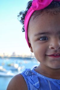 Close-up portrait of cute girl against sky