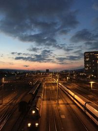 High angle view of illuminated railroad station against dramatic sky