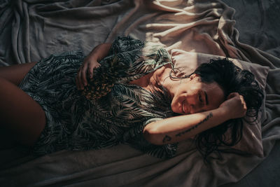 High angle view of woman sleeping on bed