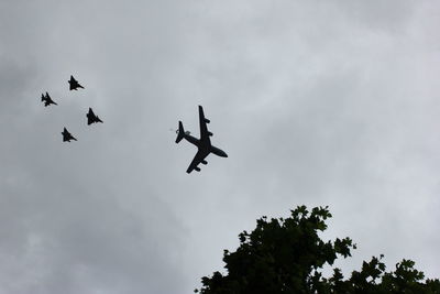 Low angle view of silhouette airplane flying against sky