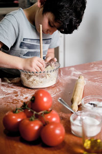 Child preparing pizza dough to make at home