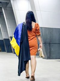 Rear view of friends standing against wall