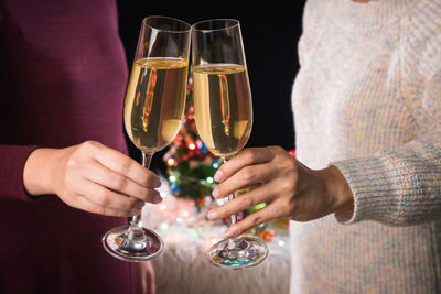 Midsection of friends toasting champagne flutes