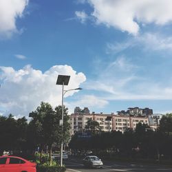 Cars on road against sky in city