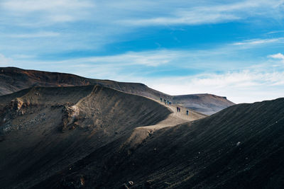 Scenic view of volcanic crater against cloudy sky