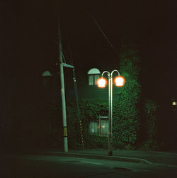 Illuminated street light on road at night