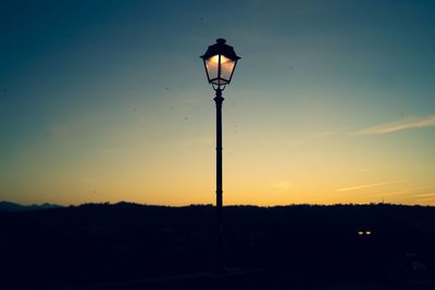 Low angle view of street light against sky at sunset