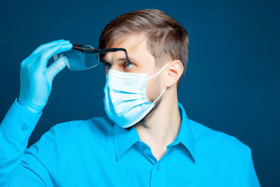 Doctor wearing mask against colored background