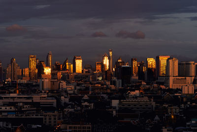 Illuminated buildings in city against sky