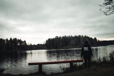 Rear view of man on lake against sky