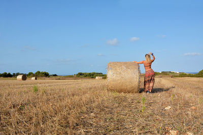 Side view of woman on field against sky