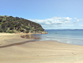 View of calm beach against blue sky