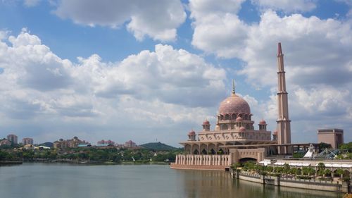 Putra mosque by lake against sky in city