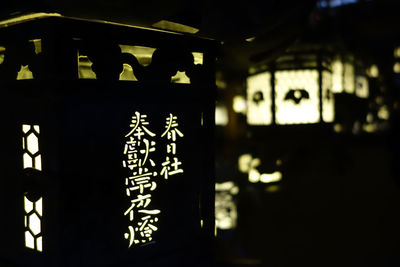 Close-up of illuminated text on wall in building