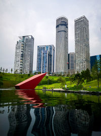 Reflection of buildings in city against sky