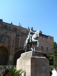 Low angle view of statue against clear blue sky