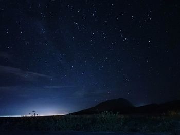 Silhouette mountain against sky at night